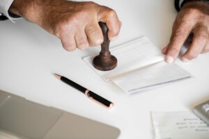 Foto de alguien estampillando un papel. Representando los procesos administrativos que debes seguir para comenzar un negocio en Colombia