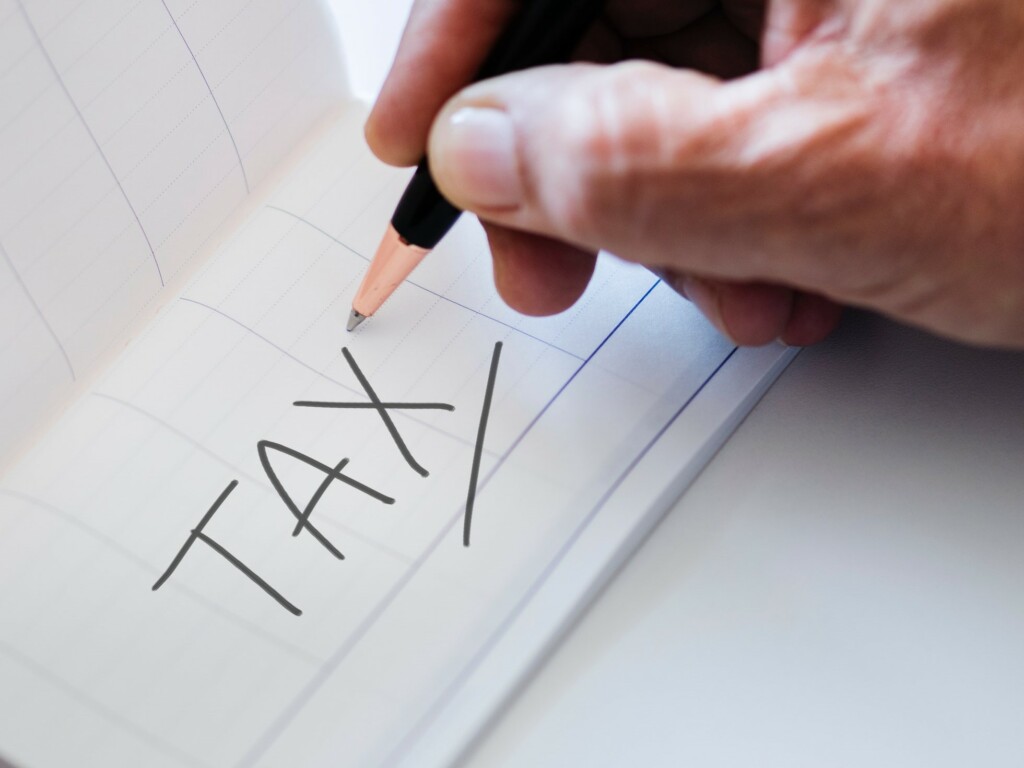 Person wiring "tax" on a white piece of paper.