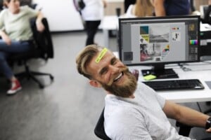 A man sitting in an office laughing, could be motivated by leadership style
