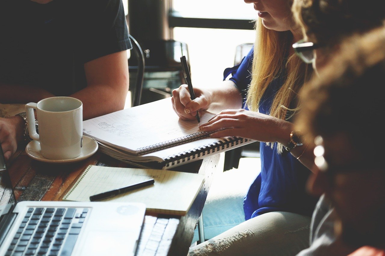 Start-up discussing with a laptop around the table if they should hire a PEO service.