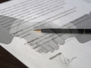 Handshake image superimposed over a signed contract