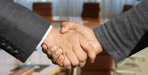 Two persons shaking hands about a trade agreement in Bolivia.