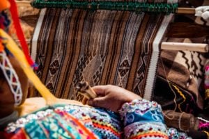 A woman weaving fabric for an NGO in Peru