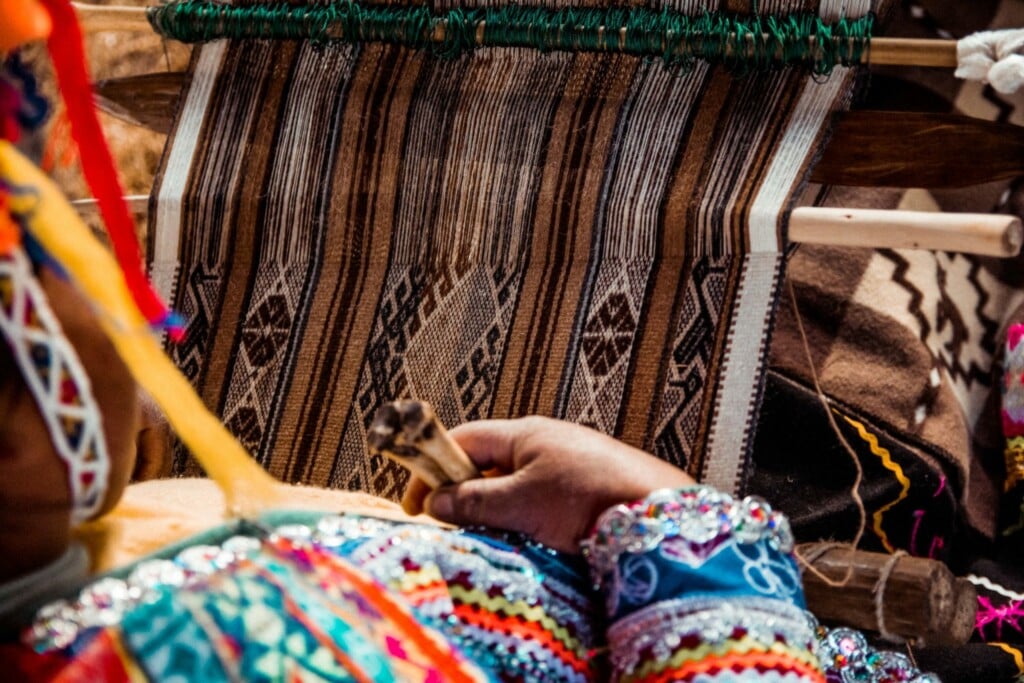 A woman weaving fabric for an NGO in Peru