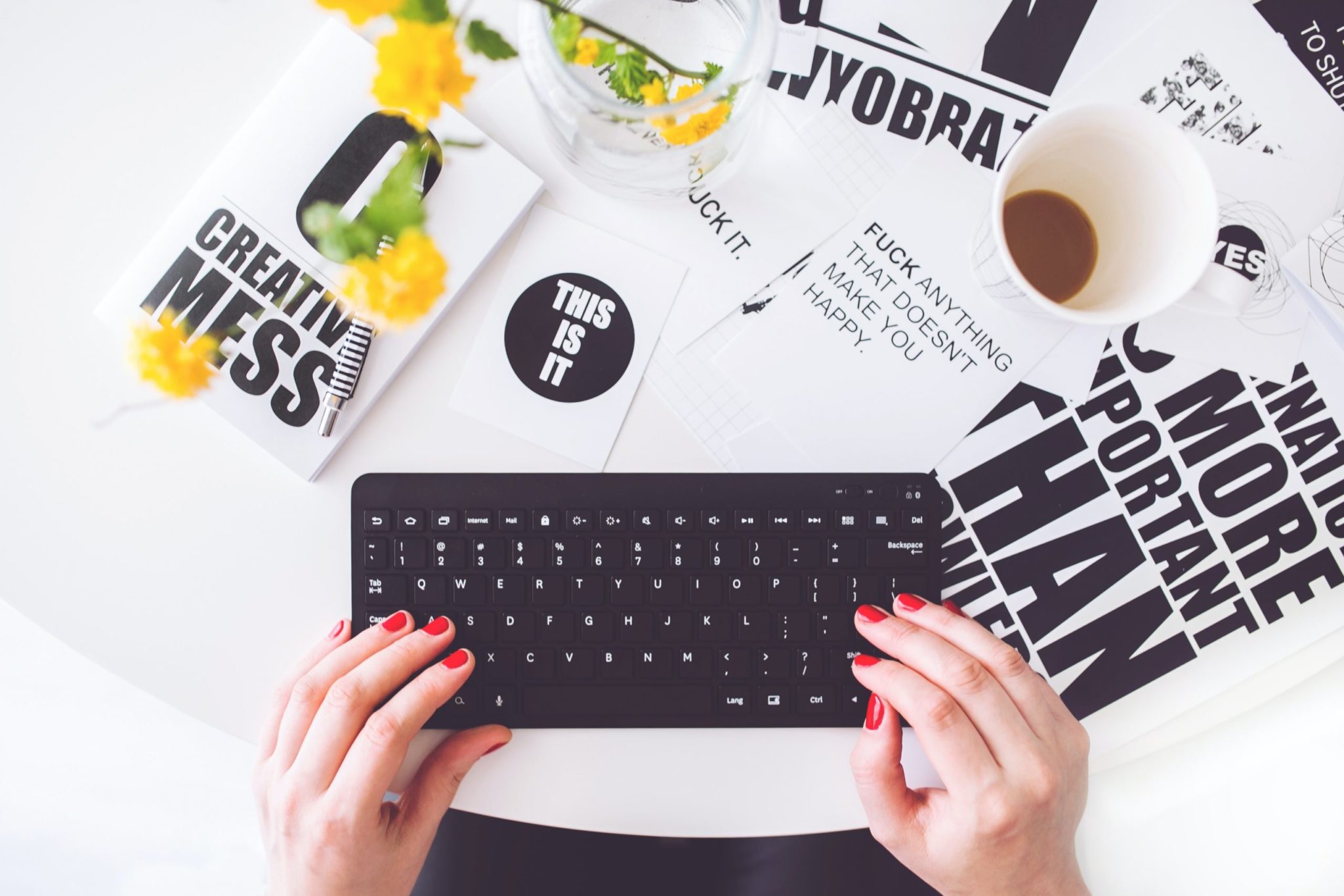 Person typing on a keyboard next to brochures