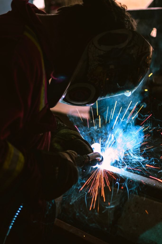 A person welding metal in a Mexico manufacturing company.