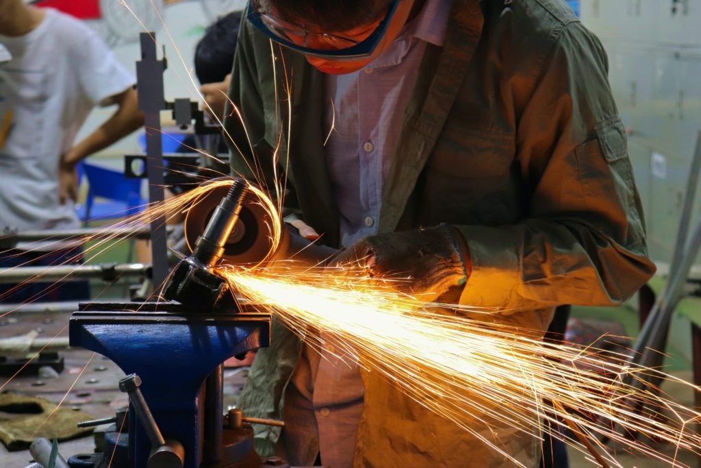 A person welding metal in Mexico's manufacturing sector