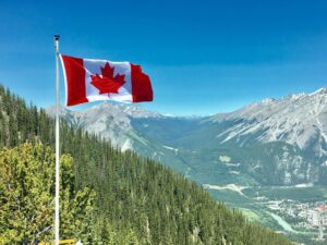 Canadian flag flying in mountains.