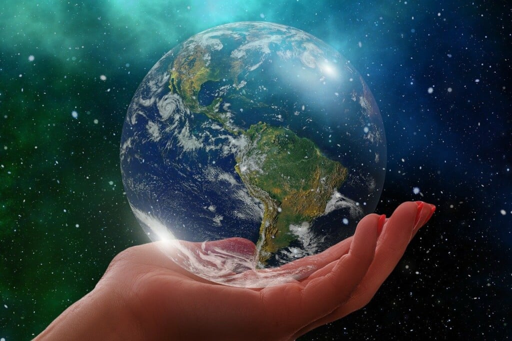 Mão segurando o planeta Terra, mostrando o continente latino-americano.