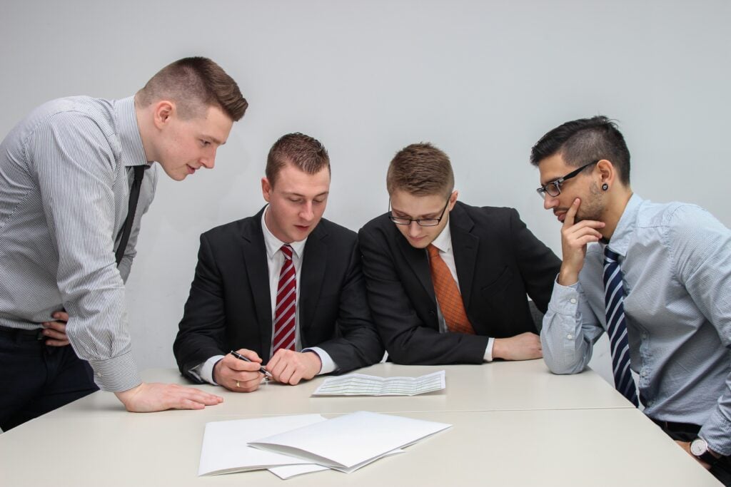 Group of people around a desk looking at paperwork