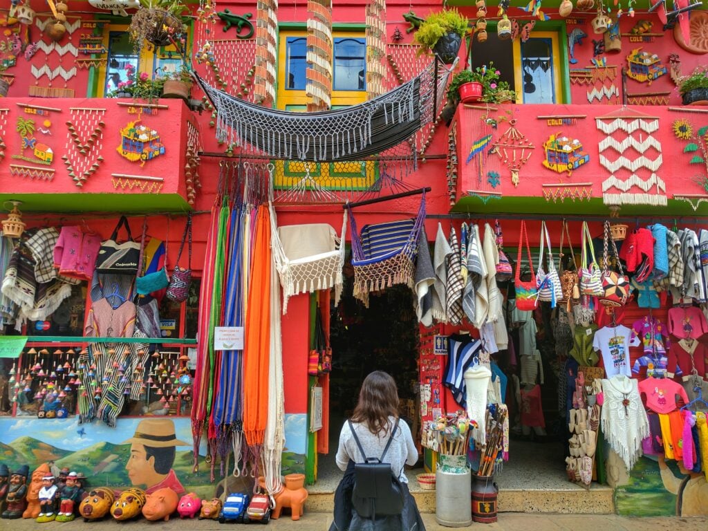 Woman standing in front of a Colombian handicraft store.