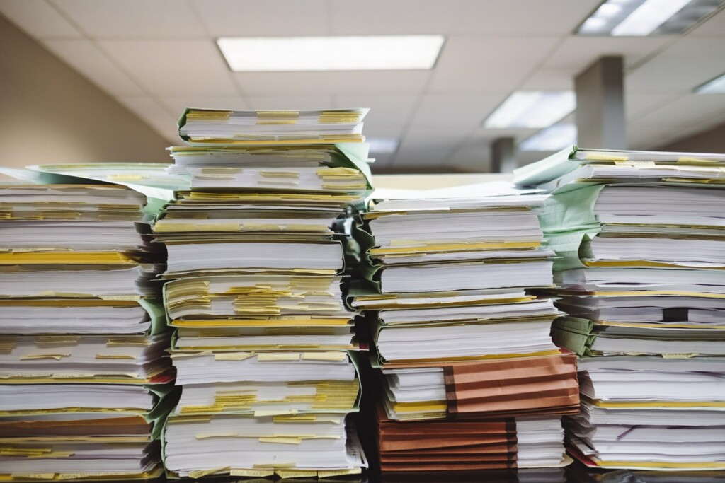 A stack of paperwork representing the large amount of records needed for an entity health check in Uruguay
