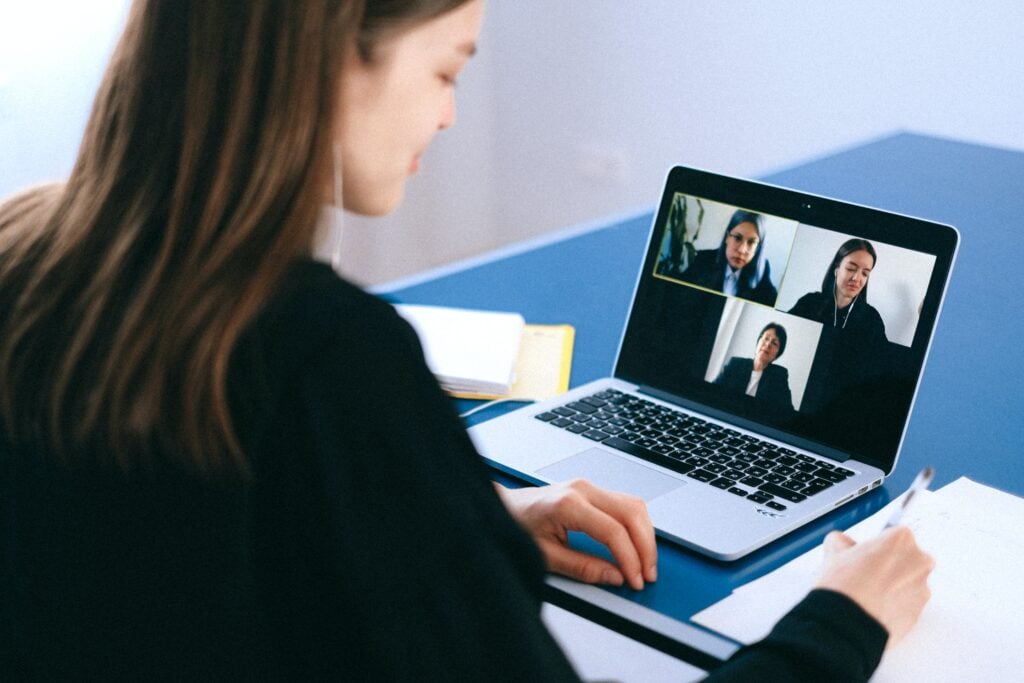 A woman having a virtual interview with two other people, representing a group of coworkers discussing about Bolivia tech companies. 