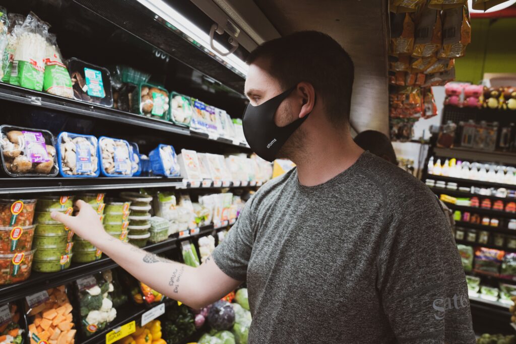 Man in a supermarket wearing a mask, representing an employee of a Paraguay startup.