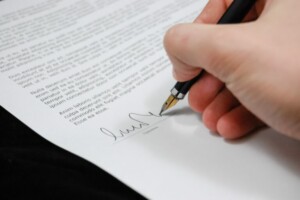 Persona que firma un documento, que representa a una persona que firma el contrato de un empleado después de realizar una verificación de antecedentes en Chile.
