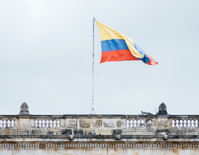 The flag of Colombia flying in capital city Bogota. You may find payroll outsourcing in Colombia is the best option for your business