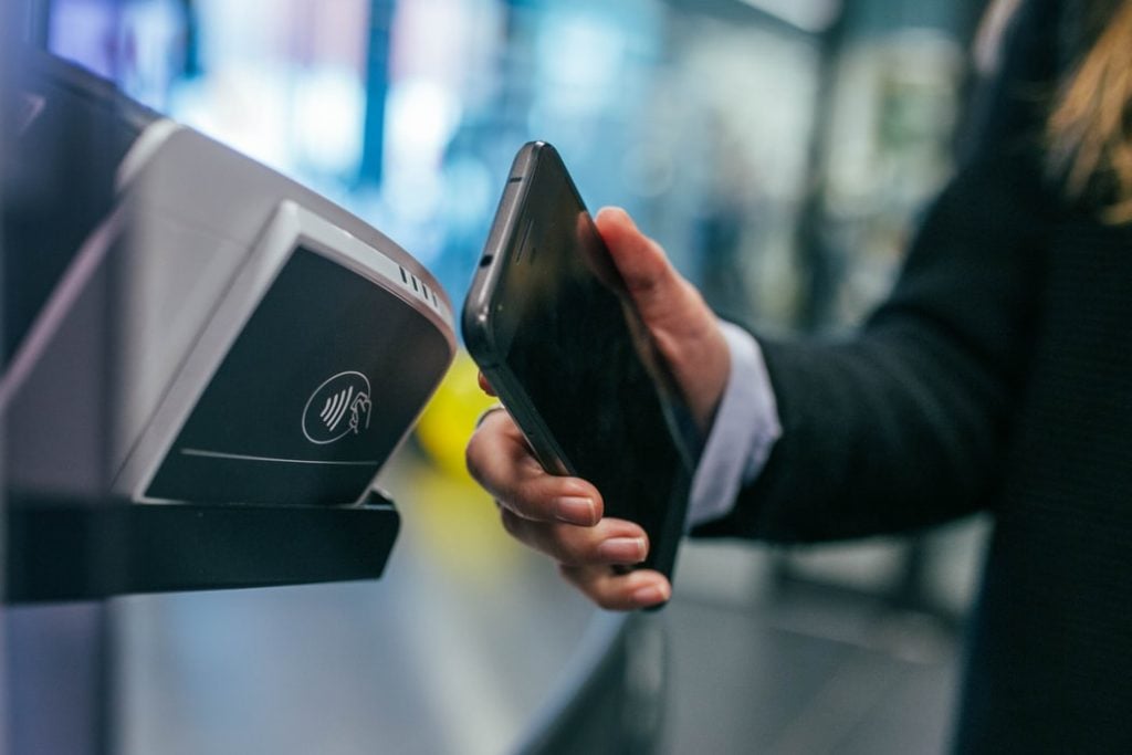 A mobile phone used to make a payment, representing fintech in Uruguay