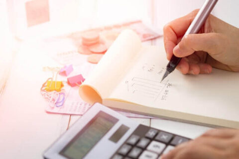 Persona usando uma calculadora, representando uma persona calculando os impostos que devem pagar para abrir uma limitada no Uruguai.