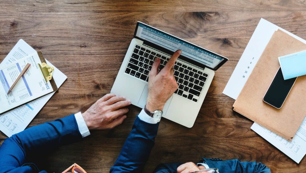 Hombre señalando un computador, representando una persona buscando información sobre Requisitos de Facturación Para una Empresa Extranjera en Guatemala.