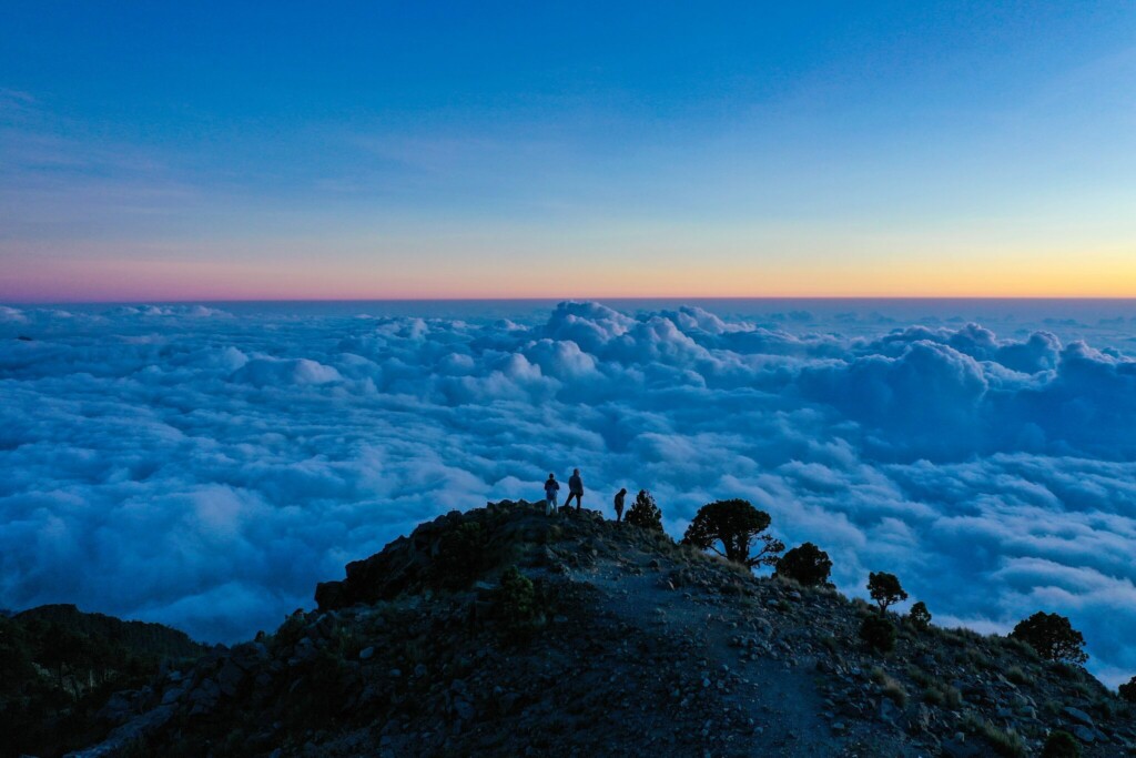 People looking over the clouds in Guatemala, where you will need a lawyer or attorney if planning to invest