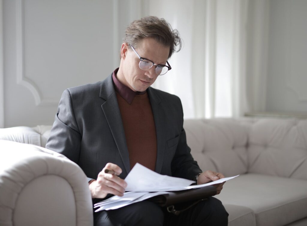 Una imagen de archivo de un hombre mirando los papeles que representan a alguien que estudia uno de los tres tipos principales de contrato utilizados en la legislación laboral de Uruguay