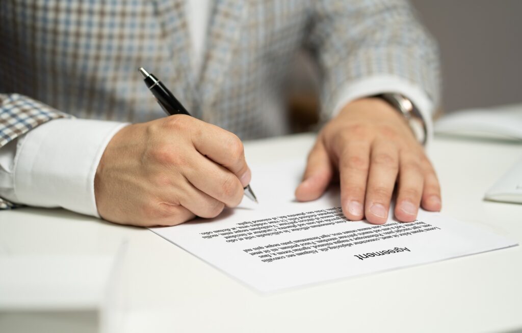 Imagen de archivo de una persona firmando un contrato para acompañar la guía de derecho laboral en Guatemala.